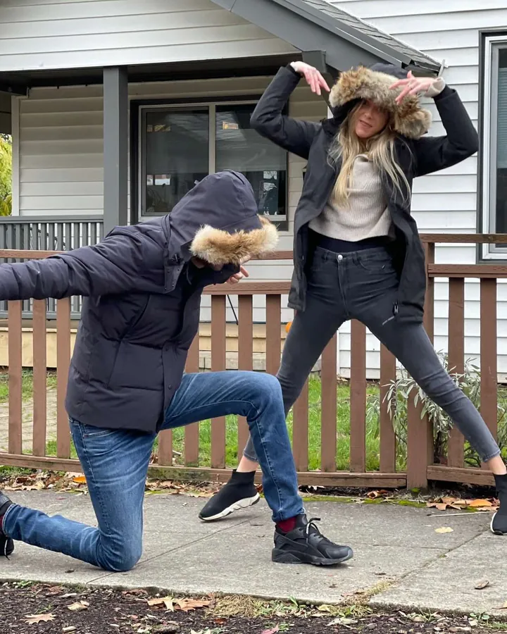 Elizabeth and Sacha striking silly poses on a sidewalk