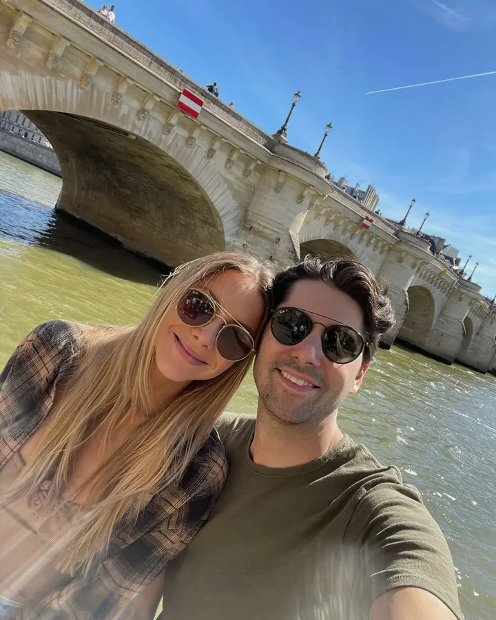Elizabeth and Sacha taking a selfie beside a stone bridge