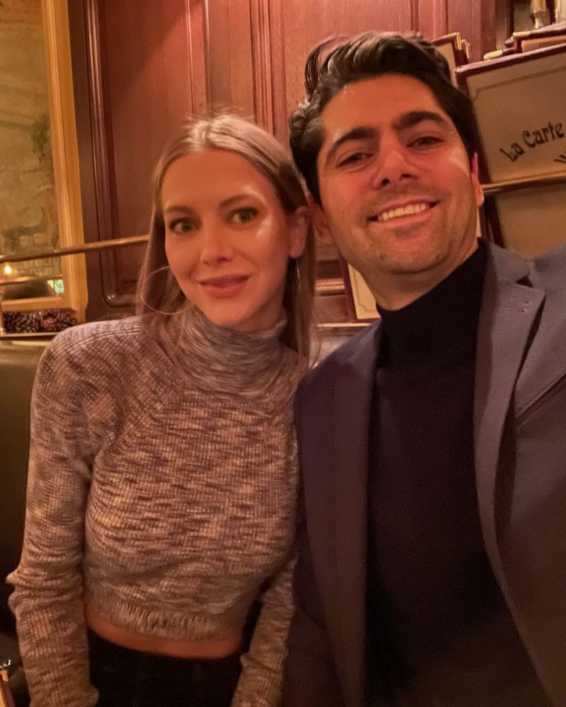 Elizabeth and Sacha in a French restaurant, beside the wine list